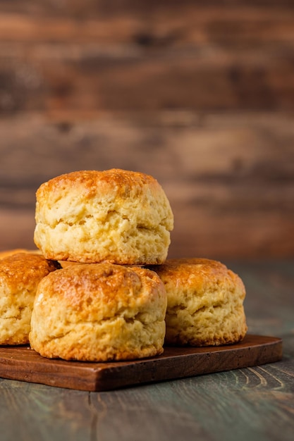 Group of scones on wood plate with jam on table