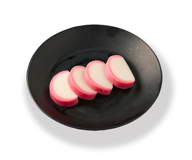 Group of set sliced fish balls plate on black plate isolated on a white background It's called Kamaboko in Japanese