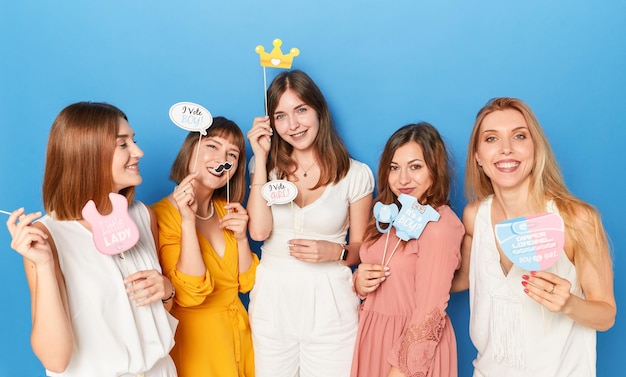 A group of smiling caucasian female models to have gender reveals envent isolated blue background