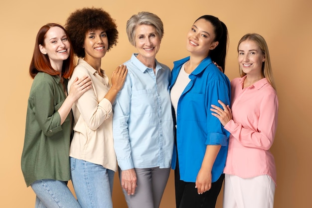 Group of smiling multiracial women wearing stylish shirts looking at camera isolated on background