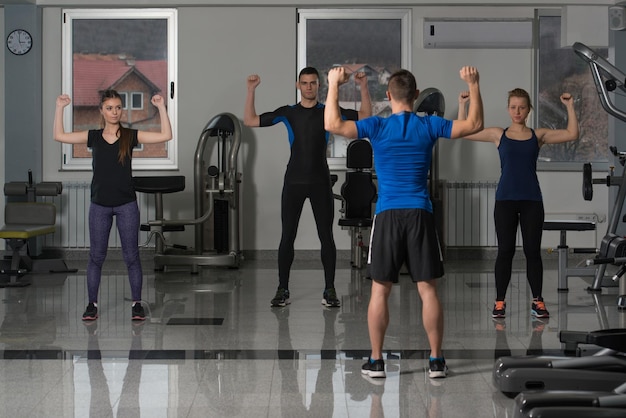 Group Of Smiling People Exercising In The Gym