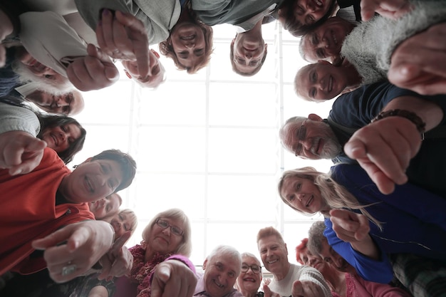 Group of smiling people pointing at the camera