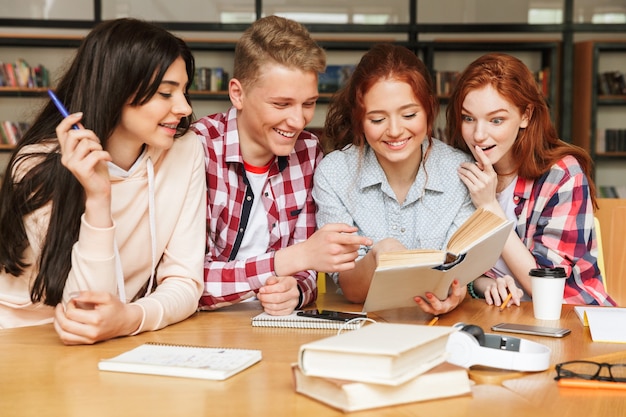 Group of smiling teenagers doing homework