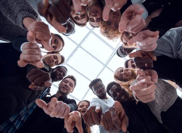 Group of smiling young people pointing at you