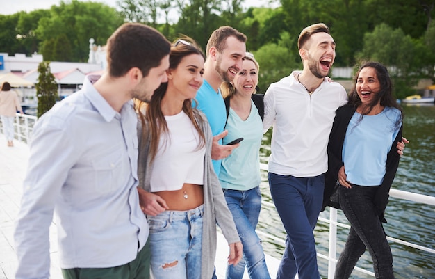 Group of smiling young and successful people on vacation on the dock.