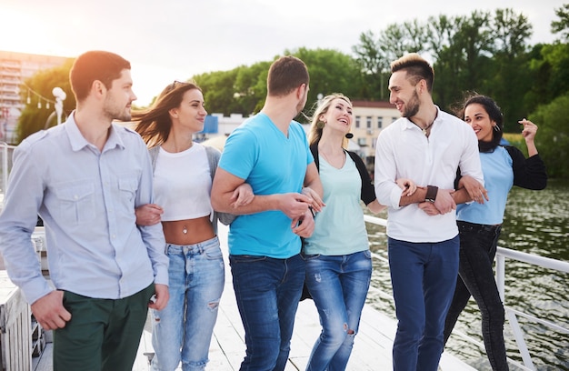 Group of smiling young and successful people on vacation on the dock.