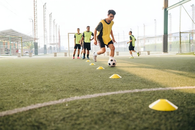 Photo a group of soccer players are on the field with yellow cones