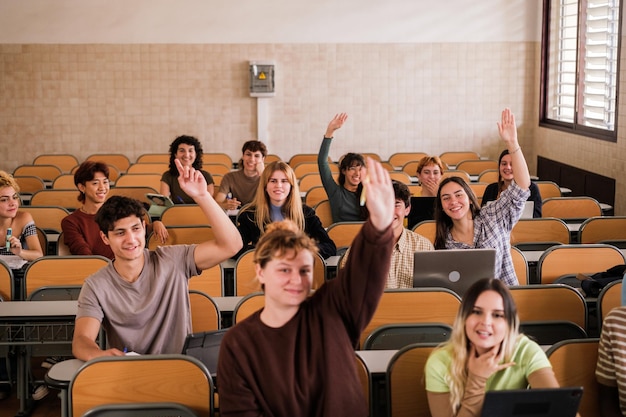 Group of students in class raising their hands to answer questions focus on the girl in the second line