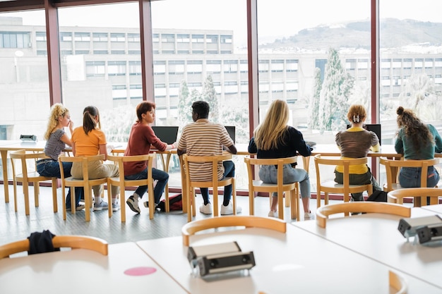 Group of students studying in front of the window of the university library