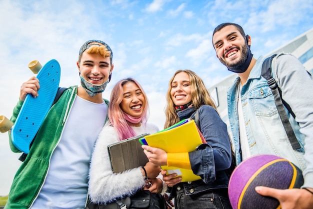 Group of students wearing protective face mask smiling and posing outdoor