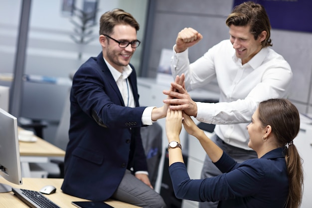 Group of successful business people cheering in modern office