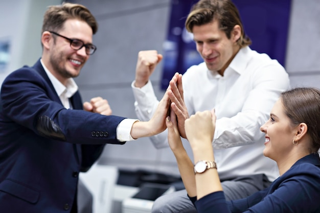 Group of successful business people cheering in modern office