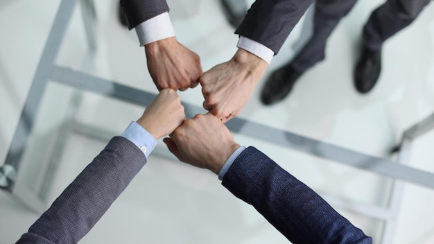 A group of successful businesspeople making fist bump together to cheer up support and making a team