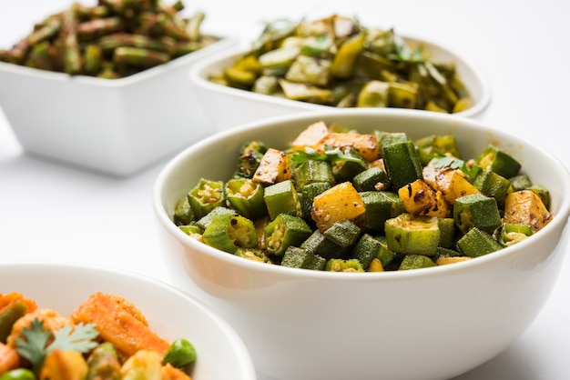 Group of Tawa fry sabzi or sabji like cauliflower or Phool Gobhi, bhindi OR okra, Gwar OR Cluster Beans, French Beans, Cabbage or Patta Gobi, Flat Green Beans, served in a bowl. selective focus