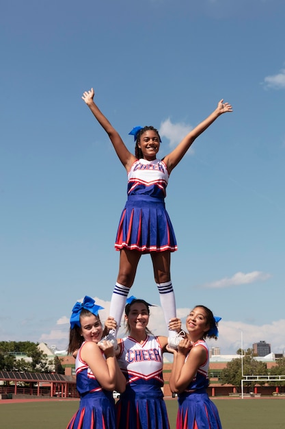 Group of teenagers in cute cheerleader uniform