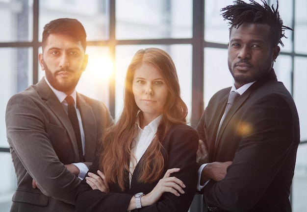 A group of three employees posing together with their arms crossed