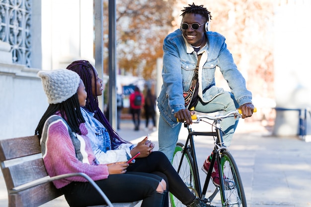 Group of three friends talking in the street.