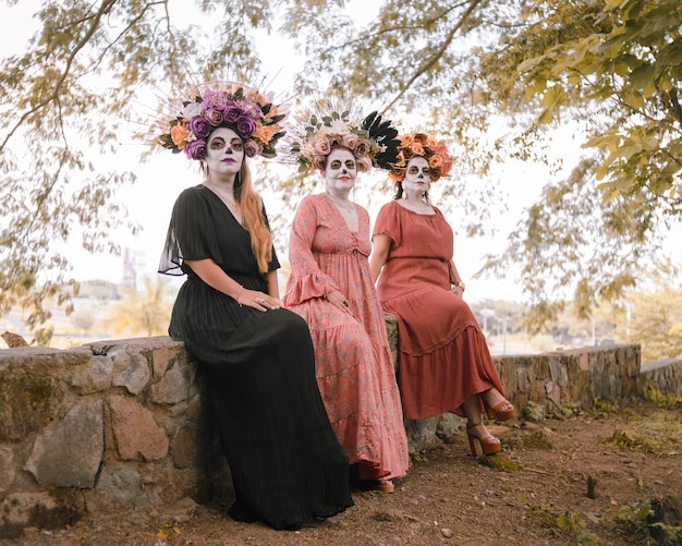 Group of three women showing catrinas make up. Makeup for the celebration of Day of the Dead.