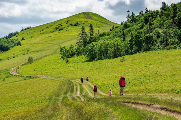 A group of tourists with large backpacks is walking along the ridge in the Carpathians Ukraine