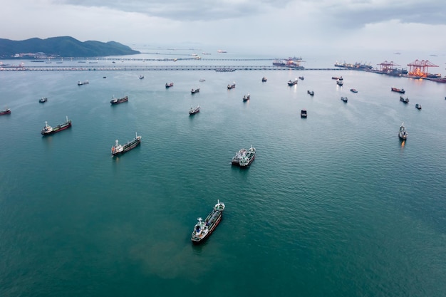 Group of transport ships waiting to carry oilgaspetrochemicals for exportfloating in sea at evening