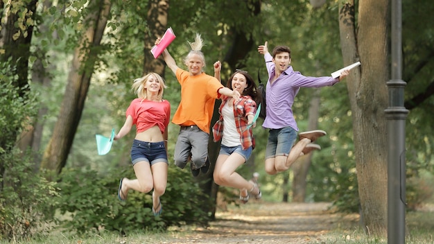 Group of triumphant students on the alley in the Park.