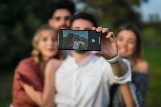 Group of two boys and two girls taking a selfie with a smartphone