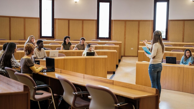 Group of university students in a circular classroom attending to the explanations of the teacher Education multicultural and science concept