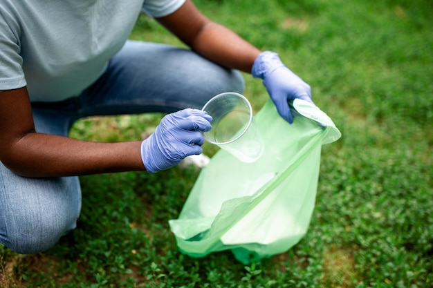 Group of volunteers cleaning up forest from waste community service concept