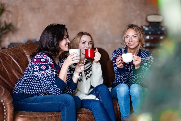 Group of women chatting while drinking coffee at modern loft