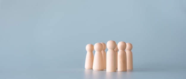 Group of wooden human figures standing in community society concept