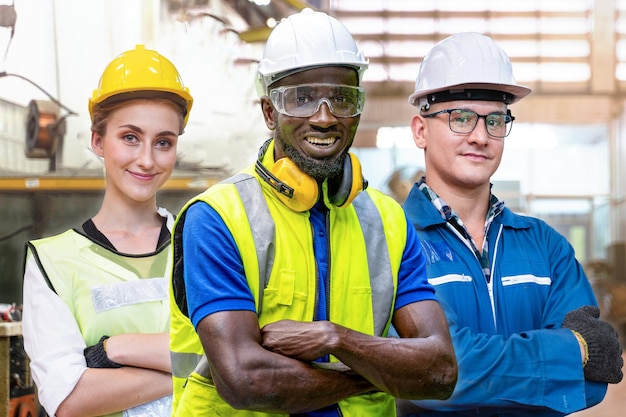 Group workers engineering standing with confident Concept of smart industry worker operating. Worker works at indoor factory with machinery equipment technology. Diversity of people of industry.