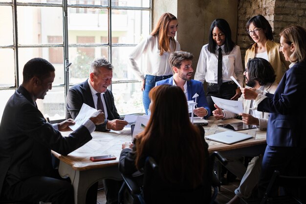 Group of workers meeting in company board room discussing and making decisions