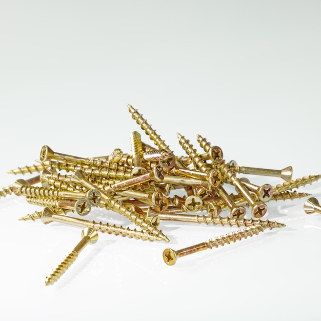 A group of yellow construction screws for connecting wooden parts