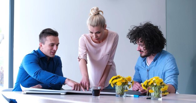 Group of a young business people discussing business plan at modern startup office building