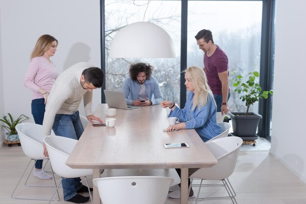 Group of a young business people discussing business plan at modern startup office building