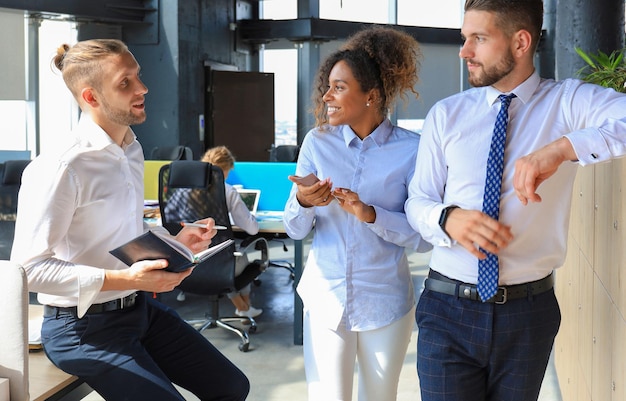 Group of young business people discussing something while working in the creative office