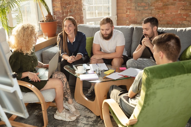 Photo group of young caucasian office workers meeting to discuss new ideas. creative meeting. teamwork and brainstorming. men and women meet in office to plan their future working. business concept.