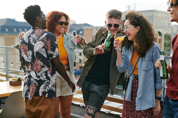 Group of young cheerful and affectionate friends enjoying outdoor party