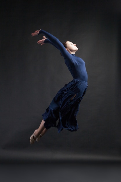 Group of young dancers in blue dresses dancing over white backgroud