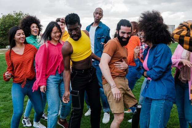 Group of young friends from different cultures and diversity dancing together in the park at sunset Concept Lifestyle outdoors pride