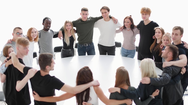 Group of young likeminded people standing around a table