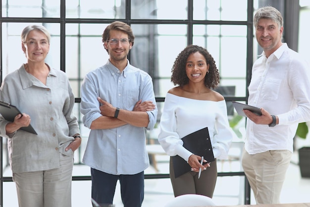 A group of young modern people in smart casual clothes studying while working in the office