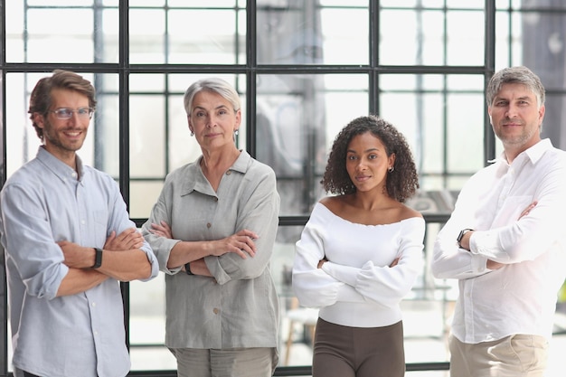 A group of young modern people in smart casual clothes studying while working in the office