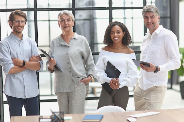 A group of young modern people in smart casual clothes studying while working in the office