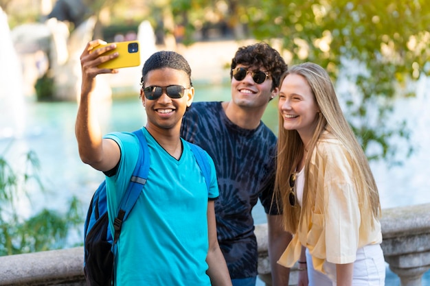 Group of young multi ethnic friends taking a selfie on vacation visiting a landmark