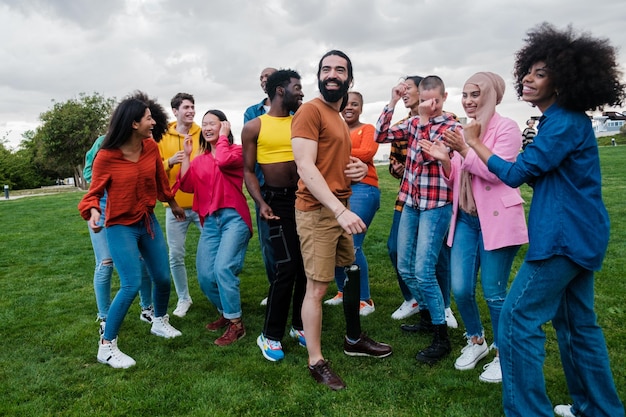 Group of young people from different cultural groups dancing in the park outdoors