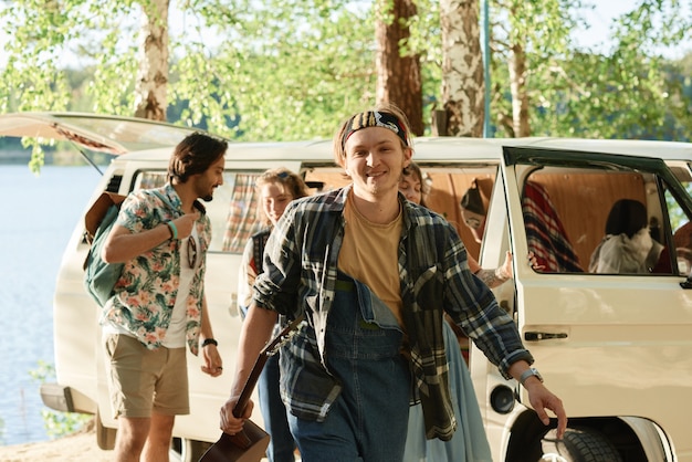 Group of young people going camping in the forest by car