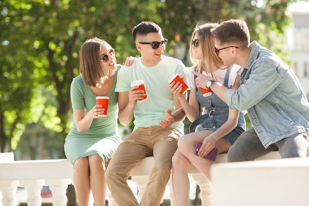 Group of young people near the fountain drinking coffee