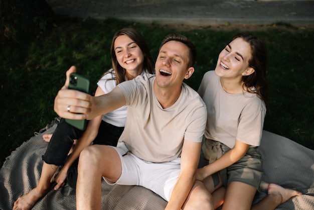 A group of young people taking selfies in nature in the park