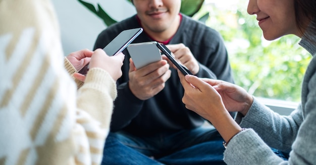 Group of young people using and looking at mobile phone together